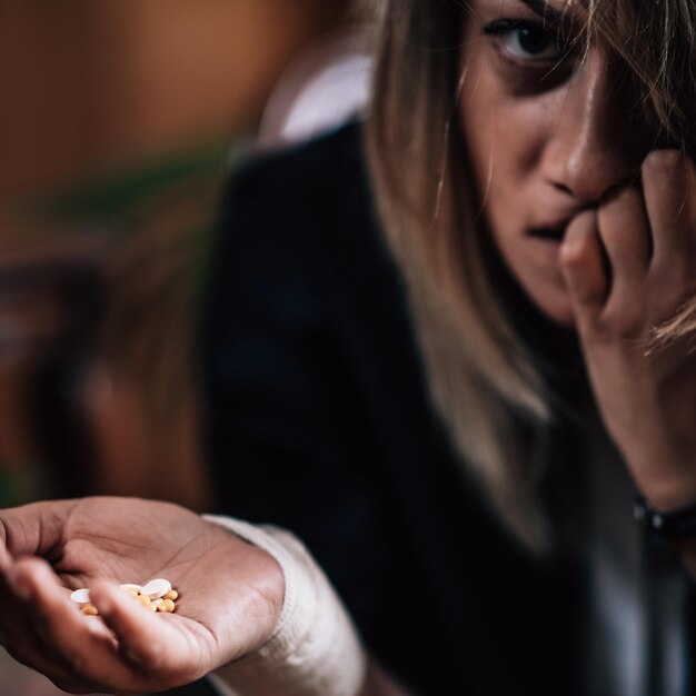 Frau mit einem Haufen Pillen in der Hand