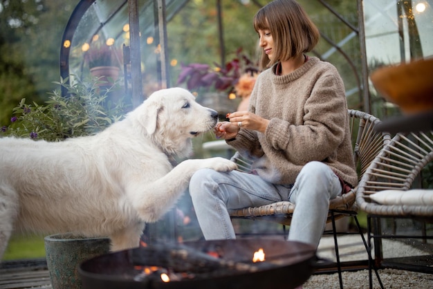 Frau mit einem Hund am Feuer im Hinterhof