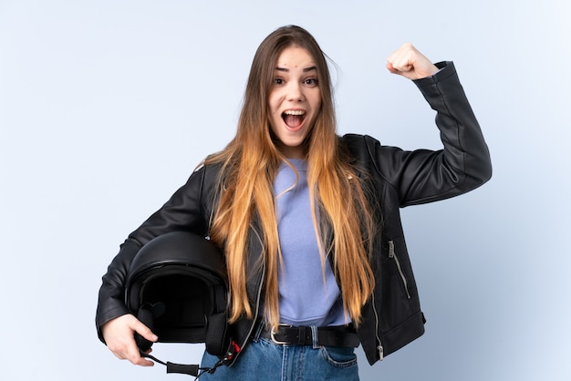 Frau mit einem Motorradhelm, der einen Sieg feiert