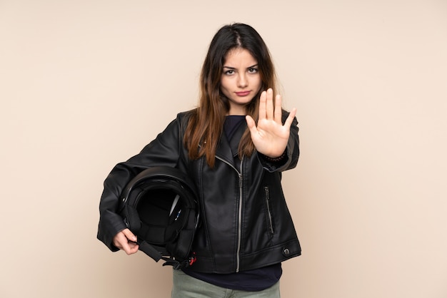 Frau mit einem Motorradhelm lokalisiert auf Beige