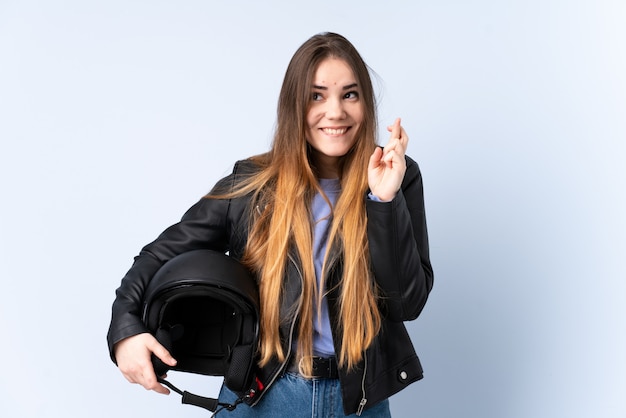 Frau mit einem Motorradhelm mit den Fingern kreuzend