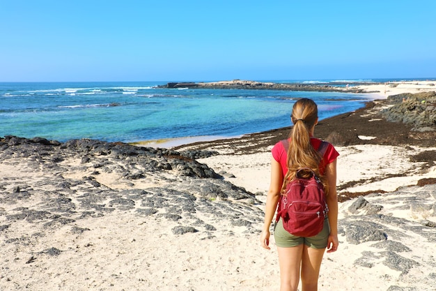 Frau mit einem Rucksack, der die Aussicht genießt