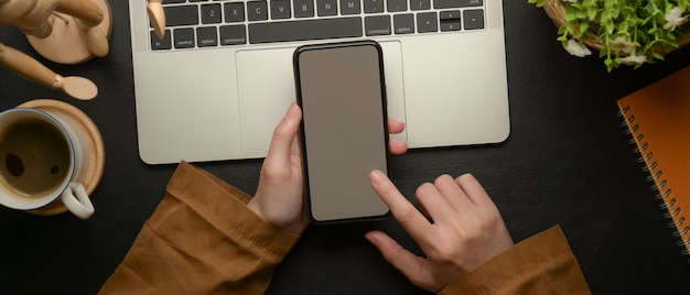 Frau mit einem Smartphone auf dem Arbeitsbereich