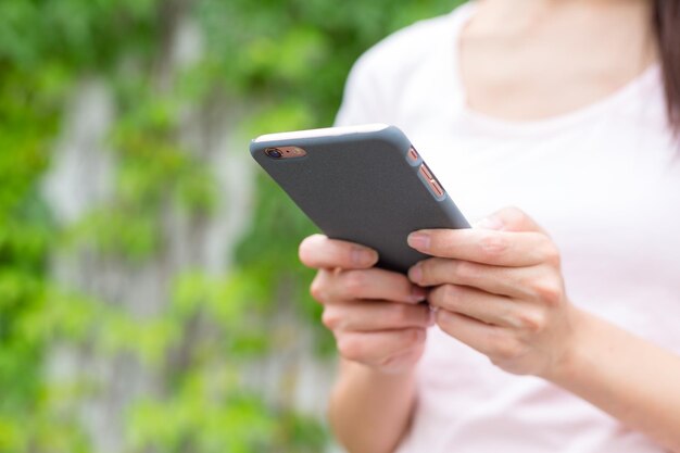 Frau mit einem Smartphone in einem Stadtpark