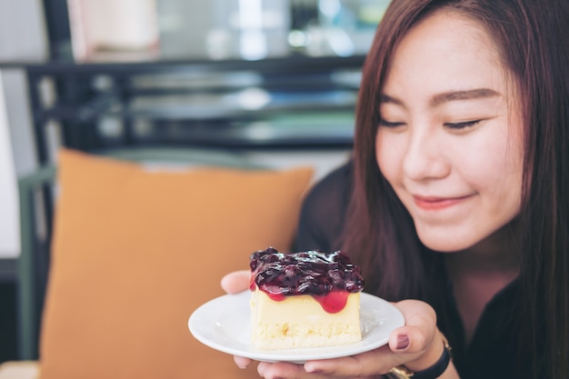 Frau mit einem Stück Blaubeerkäsekuchen