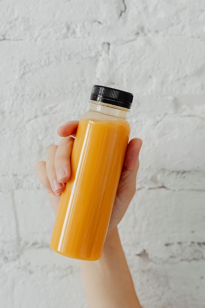 Frau mit einer Flasche Orangensaft