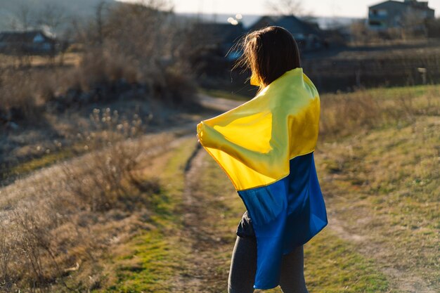 Frau mit einer gelben und blauen flagge der ukraine im freien