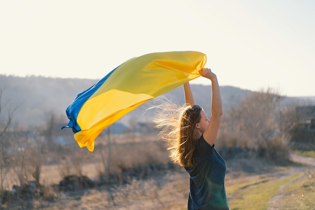 Frau mit einer gelben und blauen Flagge der Ukraine im Freien