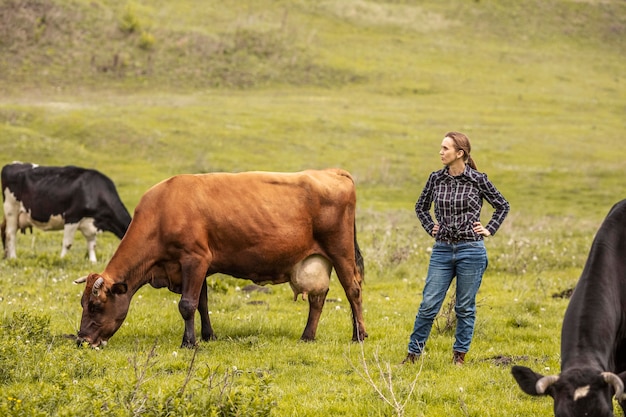 Foto frau mit einer kuh am bauernhof