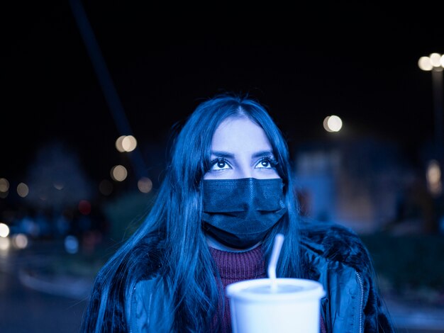 Frau mit einer Maske in einem dunklen Einkaufszentrum