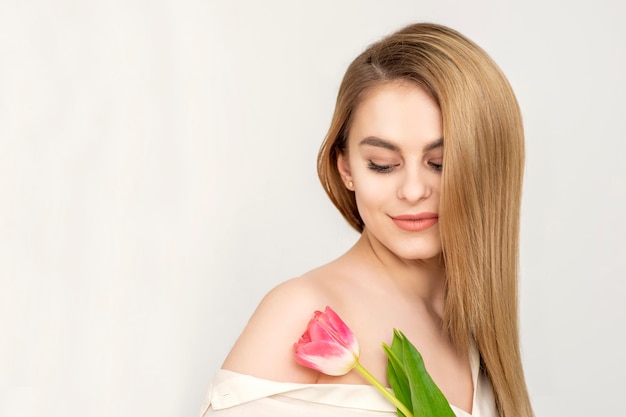 Frau mit einer Tulpe, die auf einer Blume schaut