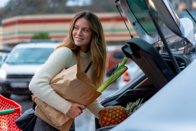 Frau mit Einkauf im Supermarkt auf dem Parkplatz vegetarisches Essen erreicht Auto