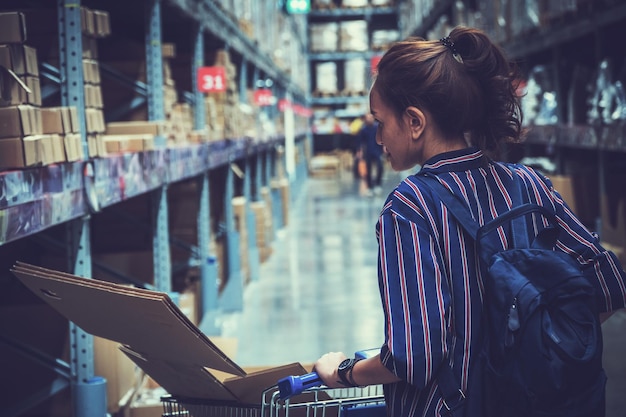 Foto frau mit einkaufswagen geht im supermarkt