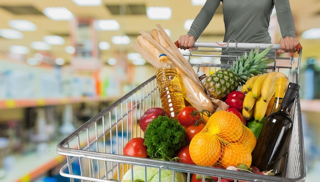 Foto frau mit einkaufswagen im supermarkt einkaufen