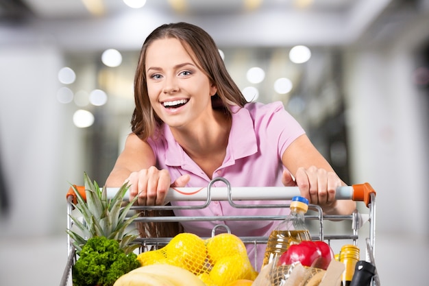 Frau mit Einkaufswagen im Supermarkt einkaufen