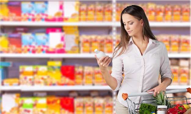 Frau mit Einkaufswagen im Supermarkt einkaufen