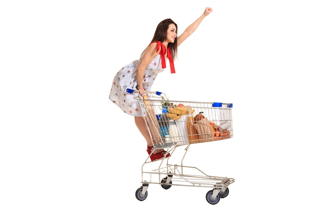 Frau mit Einkaufswagen voll mit Produkten auf weißem Hintergrund