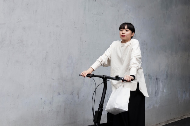 Foto frau mit elektrofahrrad in der stadt