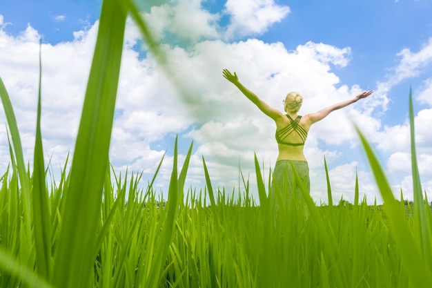 Foto frau mit erhobenen armen auf dem feld gegen den himmel