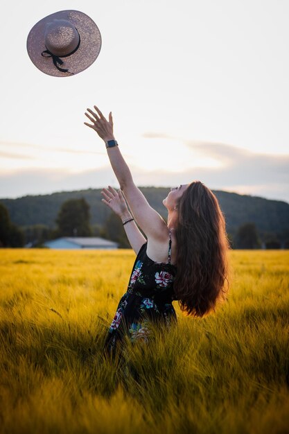 Frau mit erhobenen Armen auf dem Feld