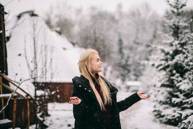 Frau mit erhobenen Armen steht im Schnee