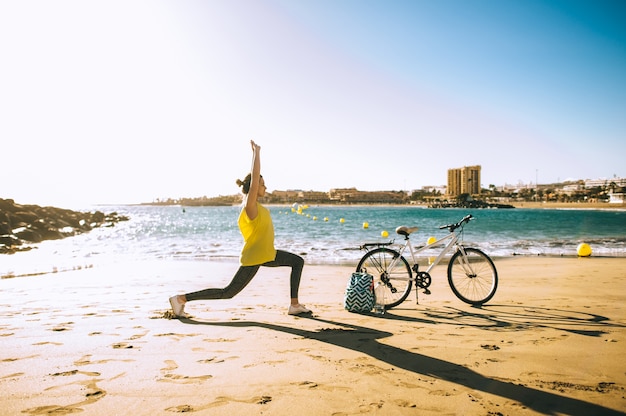 Foto frau mit fahrrad im strand