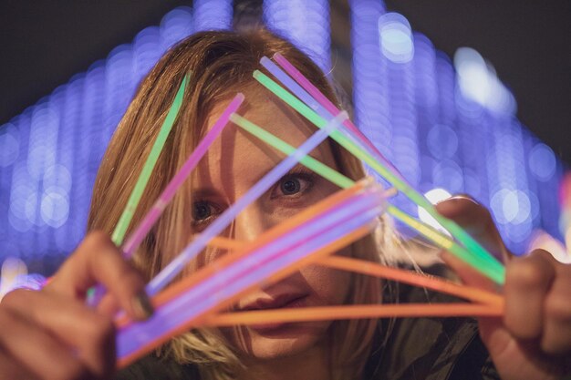 Foto frau mit farbenfroher ausrüstung in der nacht