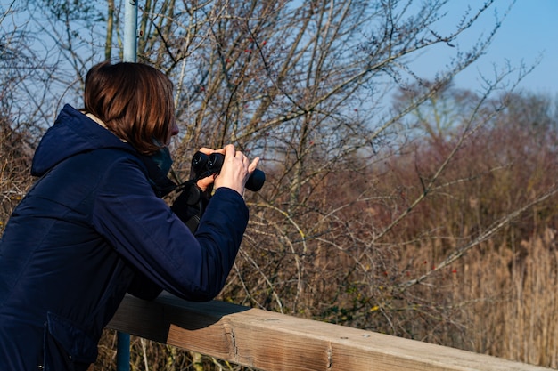 Foto frau mit fernglas, das vögel beobachtet