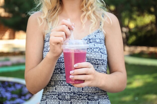 Foto frau mit frischem smoothie im freien