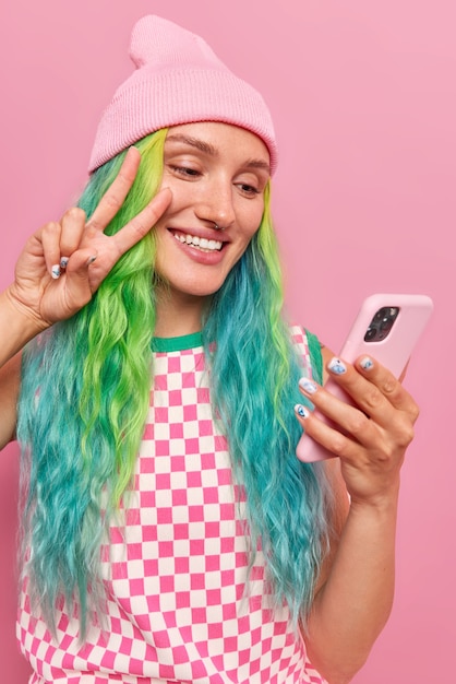 Frau mit gefärbten Haaren macht Selfie über Smartphone macht Online-Anruf kommuniziert mit Freund in stilvoller Kleidung verwendet moderne Technologien für Unterhaltung und Gespräche