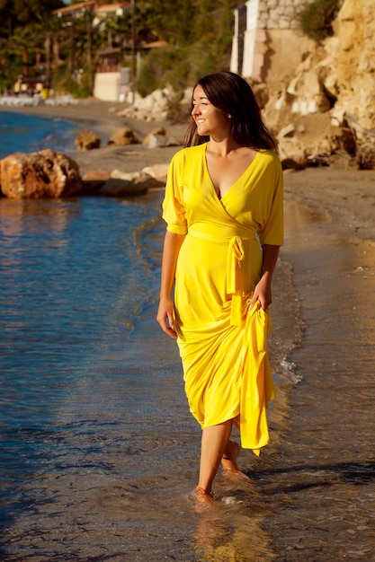 Frau mit gelbem Kleid an einem Strand