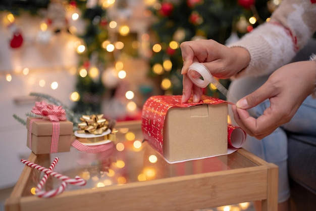 Frau mit Geschenk und Geschenk für Weihnachts- und Neujahrsparty zu Hause.