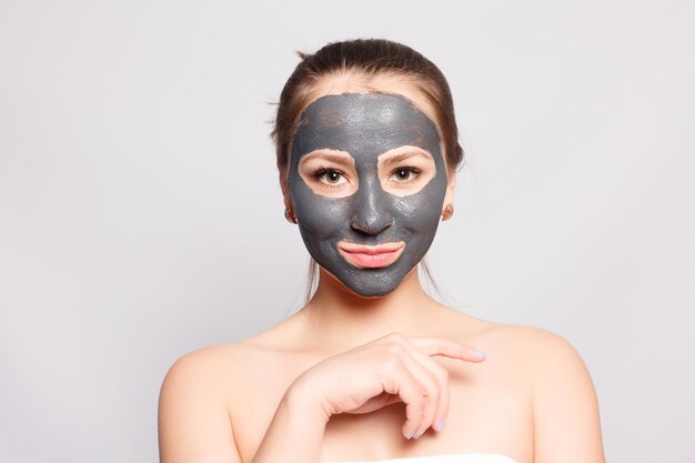 Foto frau mit gesichtsmaske porträt eines schönen mädchens, das kosmetische schwarze peeling-maske von der gesichtshaut entfernt closeup einer attraktiven jungen frau mit natürlichem make-up und kosmetischer peel-maske auf dem gesicht in hoher auflösung