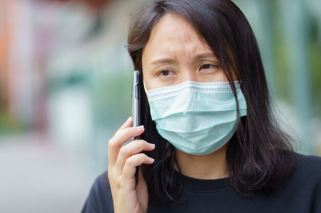 Frau mit Gesichtsmaske schützt Filter vor Luftverschmutzung oder trägt N95-Maske.