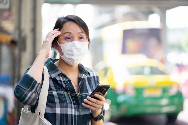 Frau mit Gesichtsmaske schützt Filter vor Luftverschmutzung (PM2.5)