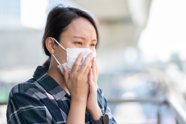 Frau mit Gesichtsmaske schützt Filter vor Luftverschmutzung (PM2.5)