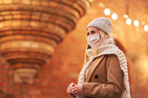 Frau mit Gesichtsmaske wegen Luftverschmutzung oder Virusepidemie in der Stadt