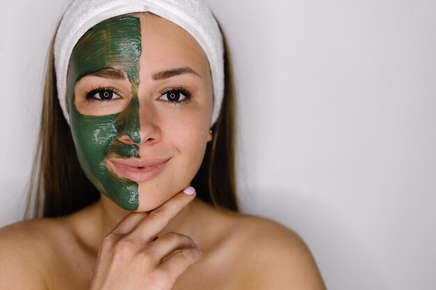 Frau mit grüner Peeloff-Maske auf ihrem Gesicht isoliert auf weißem Hintergrund