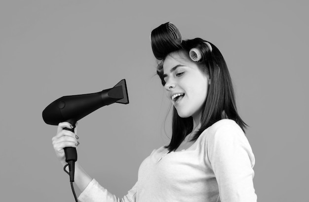 Frau mit Haartrockner schönes Mädchen mit geraden Haaren trocknet Haare mit professionellem Haartrokner