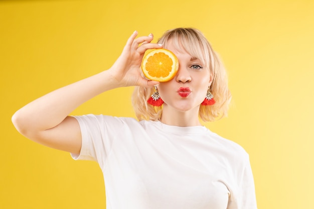 Frau mit halbiertem Orange auf ihrem Auge