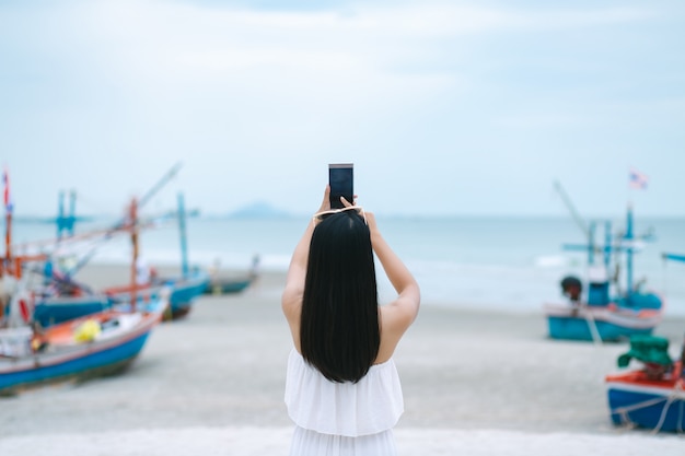 Frau mit Handy am Strand