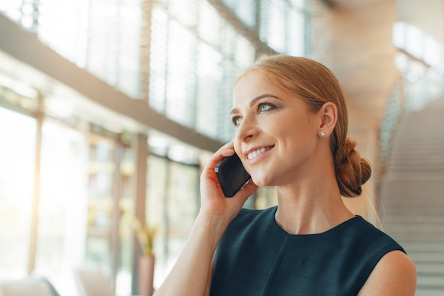 Frau mit Handy im Büro