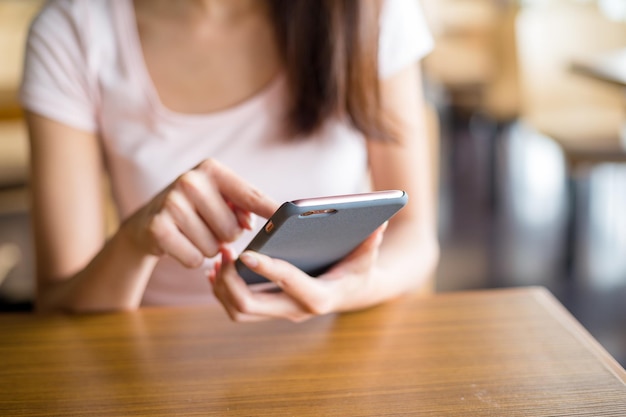 Frau mit Handy im Café