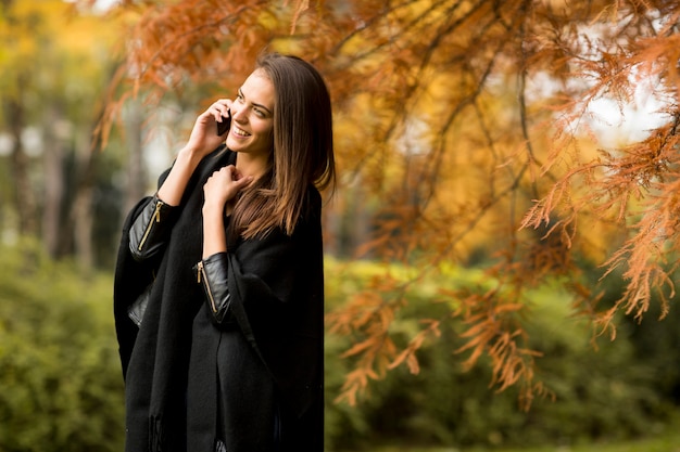 Frau mit Handy im Herbstpark