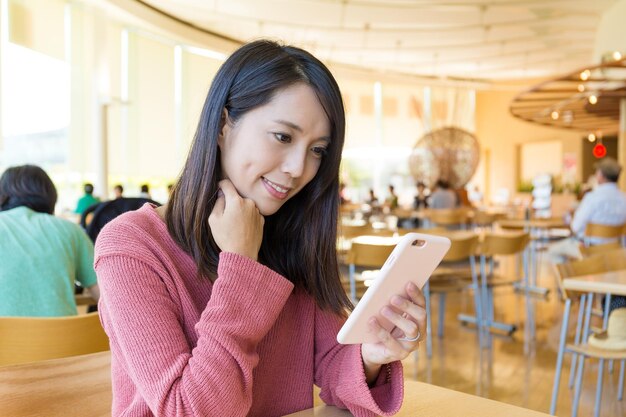 Frau mit Handy im Restaurant