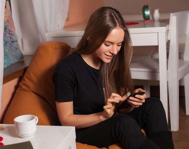 Frau mit Handy und Tasse Kaffee