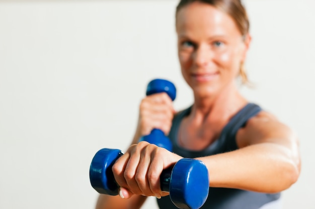 Frau mit Hanteln im Fitnessstudio