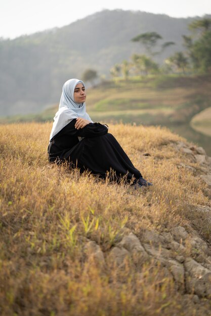 Frau mit Hijab, der draußen sitzt