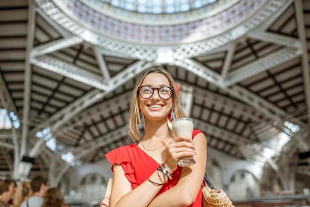 Frau mit Horchata, traditionelles spanisches Getränk aus Mandeln, stehend auf dem zentralen Lebensmittelmarkt der Stadt Valencia