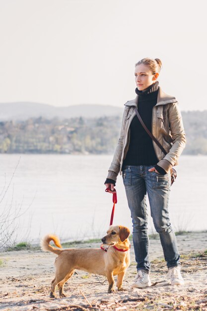 Frau mit Hund am Fluss